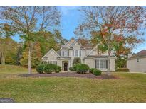 Two-story house with beige exterior, landscaping, and a walkway at 125 Fawn Brook Pass, Fayetteville, GA 30215