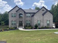 Two story house with gray brick exterior and landscaped lawn at 6164 Heavenwood Way, Douglasville, GA 30135