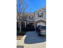 Two-story townhome with brick and siding exterior, two-car garage, and driveway at 168 Ellis Dr, Conyers, GA 30012