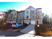 Brick townhome with attached garage and driveway, offering curb appeal at 4861 Pinnacle Dr, Stone Mountain, GA 30088