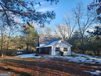 White house with a metal roof, situated on a snowy yard with surrounding trees at 873 S Antioch Rd, Mcdonough, GA 30252
