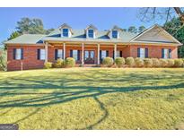 Brick home with a front porch and landscaped lawn at 145 Havenbrooke Ct, Fayetteville, GA 30214