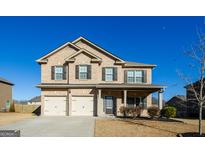Charming two-story brick home with a well-manicured front yard and a two-car garage at 5345 Bucknell Trce, Cumming, GA 30028