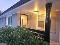 Gray house with a covered porch, landscaping, and a long driveway at 2185 Brannen Se Rd, Atlanta, GA 30316