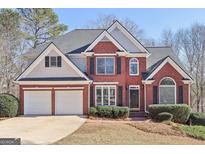 Beautiful two-story brick home with a two car garage, black shutters, and a well-maintained lawn at 5034 Hickory Hills Dr, Woodstock, GA 30188