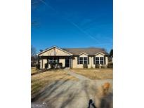 Charming single-story home featuring a well-manicured lawn and classic suburban appeal at 415 Dove Ln, Social Circle, GA 30025