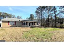 Ranch style home with a covered porch and spacious yard at 65 Merideth Trce, Sharpsburg, GA 30277