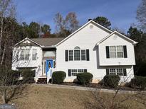 Two-story house with white siding, blue door, and landscaping at 135 Tuscany Trce, Dallas, GA 30157