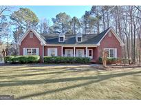 Brick house with front porch and landscaped lawn at 105 Matthew Way, Fayetteville, GA 30214