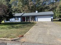 Ranch style home with attached garage and a spacious yard at 3477 Se Creekwood Se Dr, Conyers, GA 30094