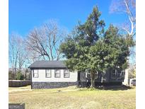 Ranch home with gray siding, stone accents, and a large tree in the front yard at 1088 Nimblewood Way, Stone Mountain, GA 30088