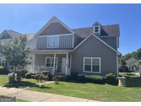 Two-story house with gray siding, front porch, and landscaping at 35 Paula Dr, Porterdale, GA 30014