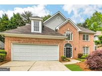 Brick house with two-car garage and landscaping at 232 Spalding Gates Drive, Atlanta, GA 30328
