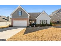 Brick and gray siding two-story house with a two-car garage at 308 San Anselmo St, Locust Grove, GA 30248