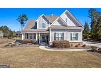 Charming gray home featuring beautiful landscaping, a welcoming porch, and classic architectural details at 244 Sturry Dr, Mcdonough, GA 30252