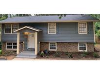 Newly painted gray house with stone accents and a landscaped yard at 2234 Cherokee Valley Dr, Lithonia, GA 30058