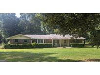 Charming single-story brick home with a well-manicured lawn and mature trees at 2215 Mount Carmel Rd, Hampton, GA 30228