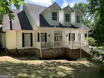 Two-story house with white siding, brick base, and a covered porch at 35 Knights Dr, Covington, GA 30016