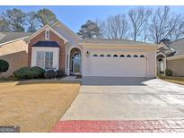Brick and stucco ranch home with attached garage and landscaping at 104 Masters N Dr, Peachtree City, GA 30269