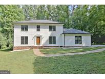 Two-story house with white siding, brown door, and landscaping at 215 Kingswood Dr, Fayetteville, GA 30215