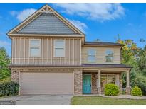 Two-story house with a neutral color scheme and a teal front door at 149 Pristine Dr, Locust Grove, GA 30248