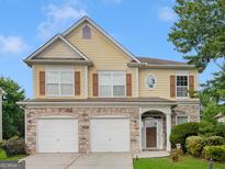 Two-story house with three-car garage, stone accents, and landscaping at 7356 Blue Jay Way, Union City, GA 30291