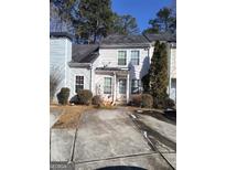Two-story townhouse with a concrete driveway and small front yard at 2590 Wellington Walk Pl, Lithonia, GA 30058