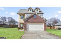 Two-story brick home with attached garage and landscaped lawn at 2171 Grant Ave, Mcdonough, GA 30252