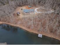Secluded lakefront property featuring a charming home, private dock, and tranquil surroundings, perfect for peaceful living at 3505 Gum Creek Rd, Oxford, GA 30054