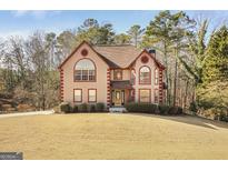 Two-story house with a brown roof, red accents, and a manicured lawn at 9361 Sweetbriar Cir, Jonesboro, GA 30236