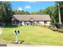 Ranch style home with a spacious lawn and mature trees at 9285 Cedar Ridge Nw Dr, Covington, GA 30014