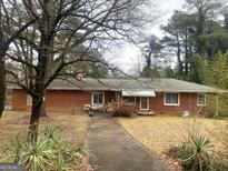 Brick ranch house with a driveway and mature trees in the front yard at 5865 Ridge Se Dr, Mableton, GA 30126