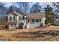 One-story house with a covered porch, green shutters, and a landscaped yard at 27 Estates Dr, Villa Rica, GA 30180