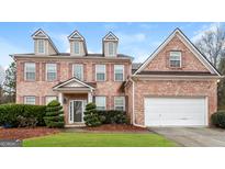 Brick two-story house with a large yard and a two-car garage at 5539 Halsey Trce, Atlanta, GA 30349