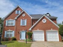 Brick house with 2-car garage, light blue shutters and landscaping at 1345 Pinebreeze Way, Marietta, GA 30062