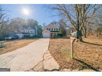 Charming two-story home featuring a well-maintained lawn and long driveway on a sunny day at 1129 Winston Dr, Decatur, GA 30032