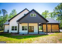 Beautiful modern farmhouse featuring a covered patio, open carport, and a light-filled, two-story design at 90 Ayers Rd, Bowdon, GA 30108