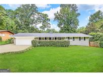 Ranch style home with attached garage and well-manicured lawn at 3721 W Potomac Dr, East Point, GA 30344