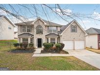 Two story brick home with attached two-car garage and landscaped lawn at 9507 Byrom Rd, Jonesboro, GA 30236