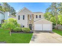 Two-story house with stone accents, two-car garage, and landscaping at 25 Alston Sw Ln, Marietta, GA 30060