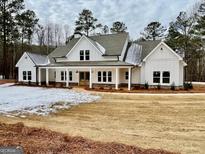 Two-story farmhouse with white siding, covered porch, and landscaping at 4619 Parkwood Rd, Social Circle, GA 30025