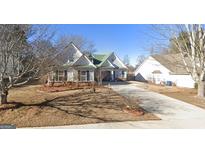 Two-story house with green roof, landscaping, and driveway at 2340 Landrum Ct, Lawrenceville, GA 30043