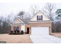 Brick house with a two-car garage and landscaping at 1431 Beckett Dr, Hampton, GA 30228