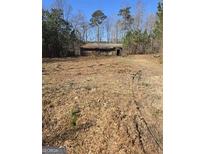 Rustic house on a cleared lot, surrounded by trees at 8025 Creekwood Dr, Fairburn, GA 30213