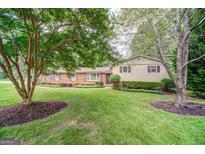 Charming brick home with well-maintained lawn, mature trees, and manicured landscaping at 3170 Ebenezer Rd, Marietta, GA 30066