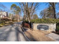 Stone sign welcomes you to Rivermont: The Village, situated in a peaceful neighborhood with tree-lined streets under a clear blue sky at 306 Hawkstone Way, Alpharetta, GA 30022