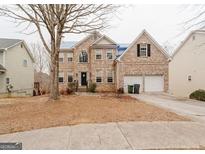 Brick two-story house with a two-car garage and mature trees at 504 Serene Waters Trl, Jonesboro, GA 30236