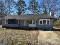 Newly painted gray house with a paved driveway and mature trees at 285 Queen Helen Ln, Jonesboro, GA 30236