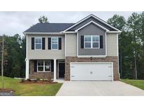 Two-story house with gray and beige siding, white garage door, and landscaping at 513 Vervain Drive # 171, Locust Grove, GA 30248