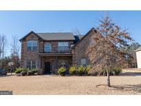 Brick two-story house with landscaping and a large yard at 160 Traditions Ln, Hampton, GA 30228